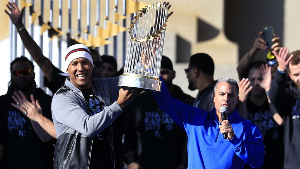 Kansas City Royals catcher Salvador Perez, left, and general manager Dayton Moore hold the World Series trophy during a rally in Kansas City, Mo., Tuesday, Nov. 3, 2015. (AP Photo/Orlin Wagner)