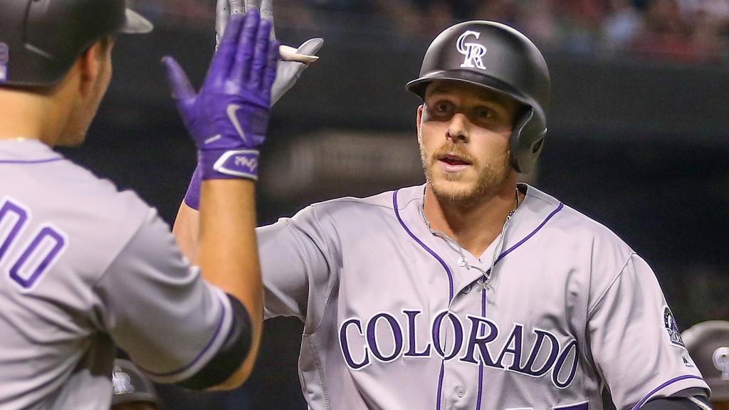 PHOENIX, AZ - APRIL 04:  Trevor Story #27 of the Colorado Rockies high fives Nolan Arenado #28 after Story hit a three-run home run against the Arizona Diamondbacks during the third inning of the MLB opening day game at Chase Field on April 4, 2016 in Phoenix, Arizona.  (Photo by Christian Petersen/Getty Images)