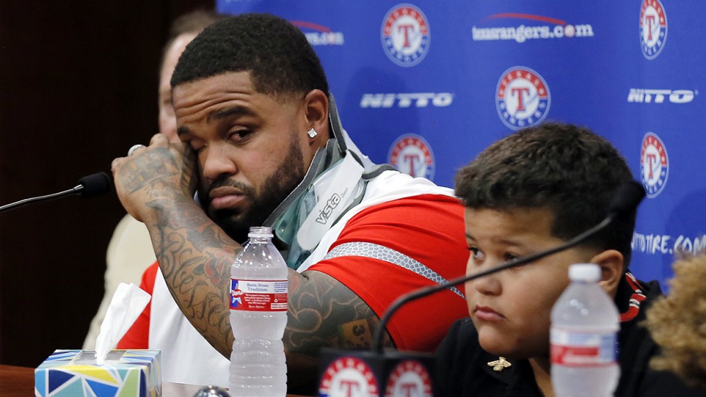 Texas Rangers' Prince Fielder, left, wipes his eyes as he sits by his son Haven during a news conference before a baseball game against the Colorado Rockies, Wednesday Aug. 10, 2016, in Arlington, Texas. The 32-year-old slugger won't play baseball again, unable to come back after his second neck surgery. (AP Photo/Tony Gutierrez)