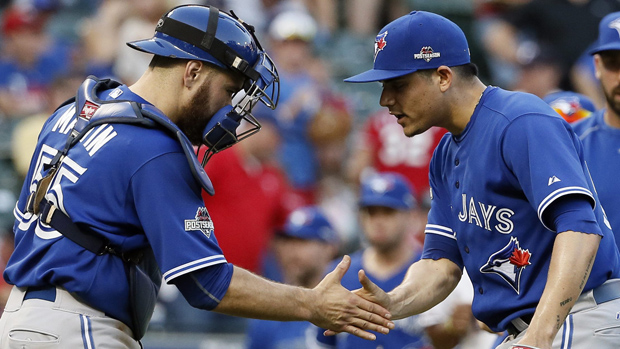 Toronto Blue Jays catcher Russell Martin (55) and relief pitcher Roberto Osuna (54) celebrate beating the Texas Rangers 8-4 at Game 4 of baseball's American League Division Series Monday, Oct. 12, 2015, in Arlington, Texas.(AP Photo/Tony Gutierrez)