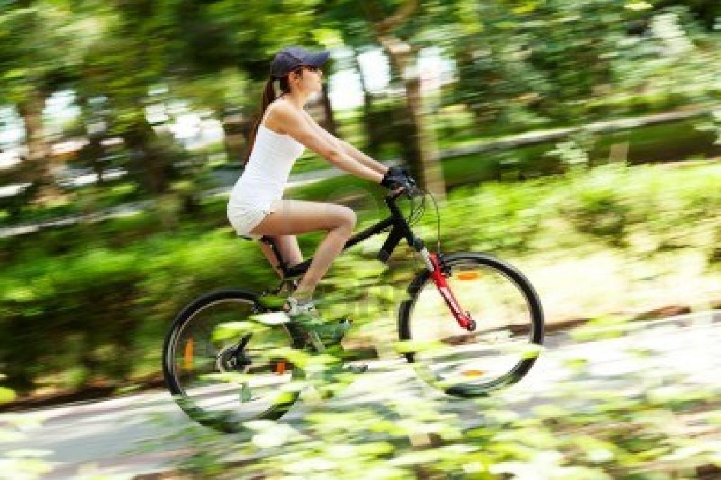 11784344-chica-en-bicicleta-por-el-parque-movimiento-blured-imagen