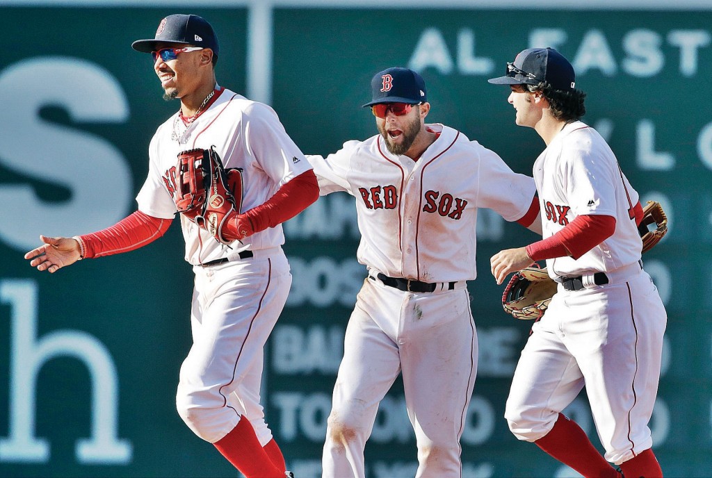 Boston Red Sox, from left, Mookie Betts, Dustin Pedroia and Andrew Benintendi celebrate after a baseball game against the Pittsburgh Pirates at Fenway Park, Monday, April 3, 2017, in Boston. The Red Sox won 5-3. (AP Photo/Elise Amendola)